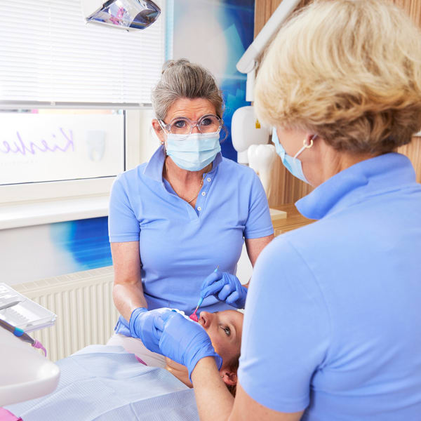 Dentist and dental assistant in conversation