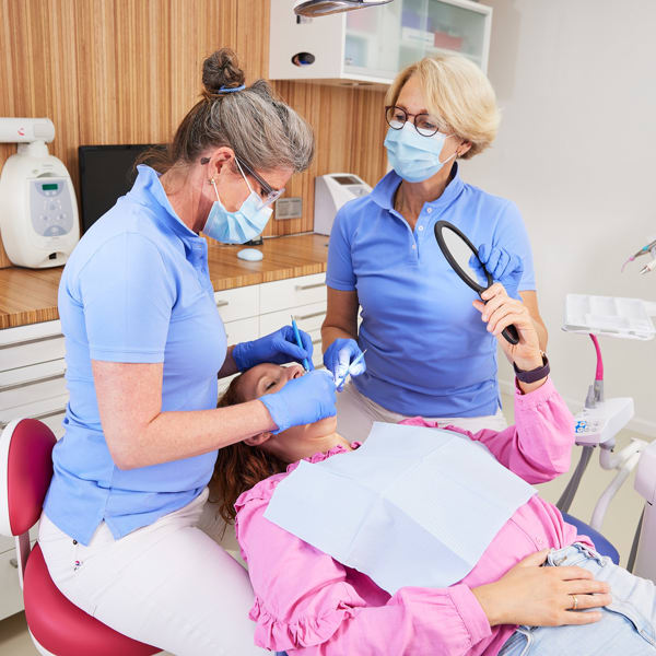 Dentist and dental asistant with a patient